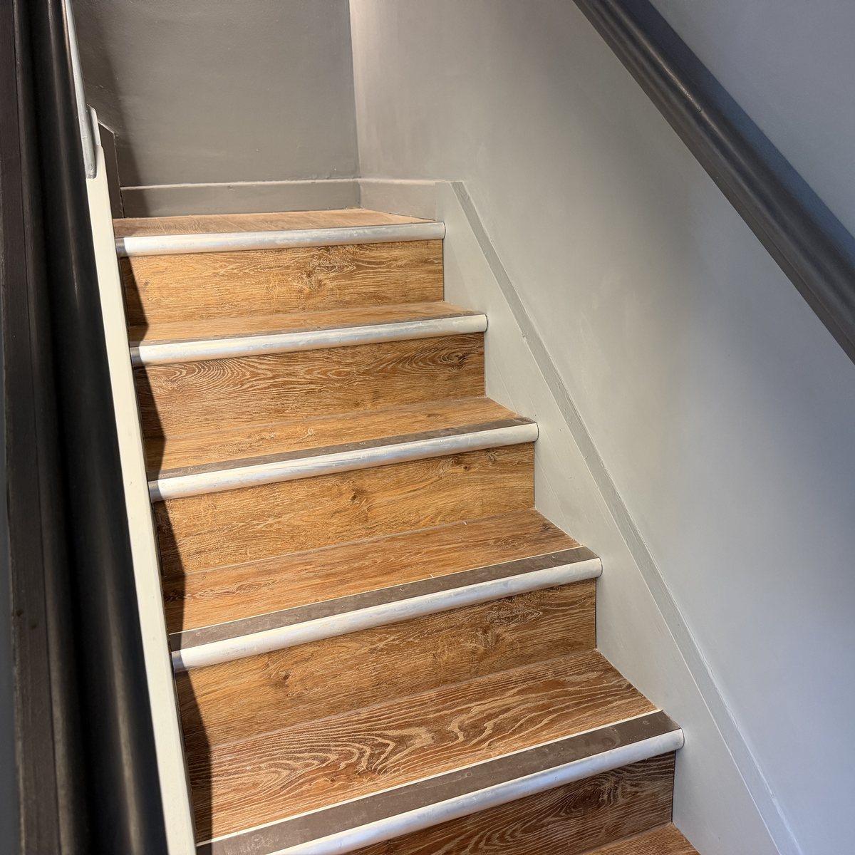Stair treads with concealed strip lighting along the wall
