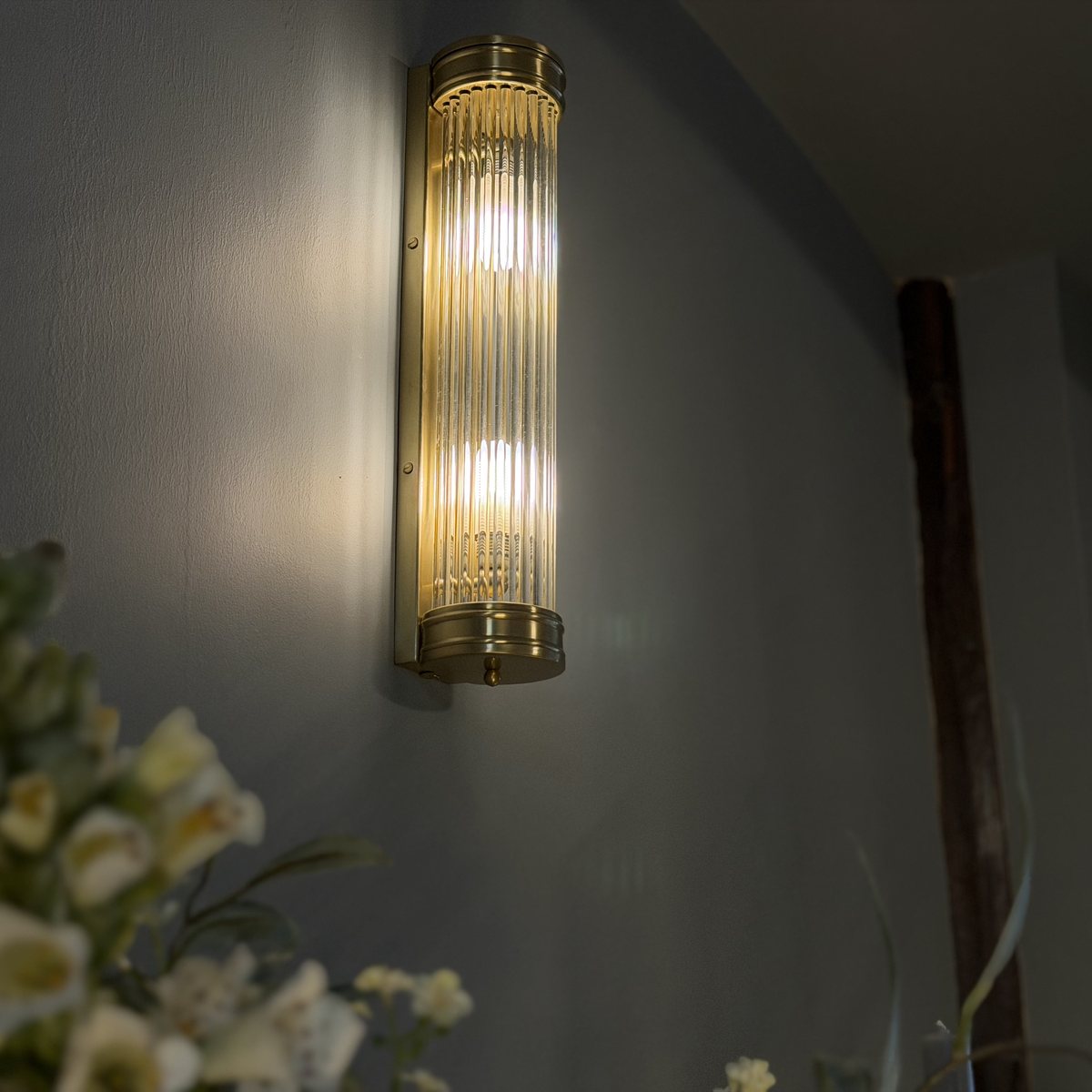 Brass ribbed wall light on a dark painted wall