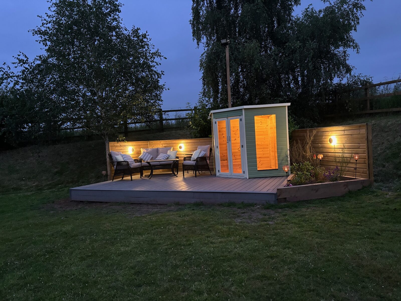 Garden room and lit decking at dusk