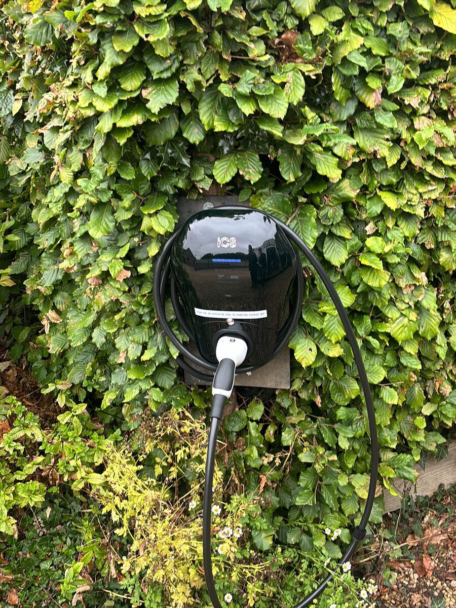 Charger tucked into an ivy-covered wall