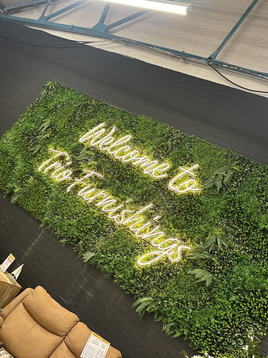 Neon welcome lettering on the living-wall feature